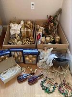 Photo showing majority of the decorations in two boxes plus angels, stars and violins laid out in front.