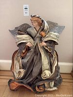 Full view of the large papier mache angel statue with flowing robes and wings, showing overall condition and size.