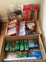 Photo showing boxes of Christmas gift bags and greeting cards arranged on floor