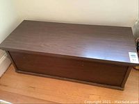 Top and side view of rectangular wooden storage chest with medium brown finish and surface marks