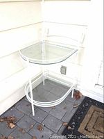 Side view of metal frame and glass surfaces, showing details of curved accents and structure.