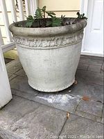 Full view of the large cement planter on porch showing overall size, shape, and condition.