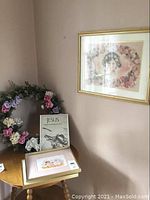 Photo of 22-inch floral wreath on small wood table with three framed prints displayed, including the signed print by Wendy Tosott and two smaller framed pictures