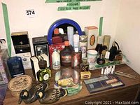 Wide view of vintage men's and women's toiletry bottles, soaps, tanning creams, vanity tray with cup, and decorative duck figurines arranged on surface.