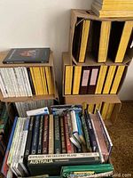 Stack of boxed National Geographic magazines and books on a carpeted floor.