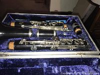 B&H clarinet disassembled inside blue velvet-lined case showing body sections and keys