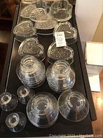 Photo showing a variety of clear glass bowls and heart-shaped glass bowls with embossed patterns.
