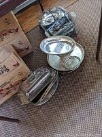 Photo showing covered serving dish, round tray with footed bowl, and a wire basket containing other items