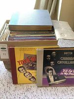 Box containing about 20 vintage LP records with visible titles and covers from Columbia and Decca labels.