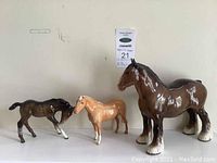 Three Beswick ceramic horses displayed side by side showing relative sizes and colors.
