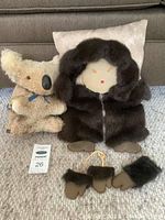 Koala plush toy and fur doll pillow with gloves shown together on carpet with pillow in background