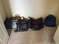 Photo showing four bags: brown leather briefcase, black leather bag, purple Spalding sports bag, and blue backpack arranged on carpeted floor.