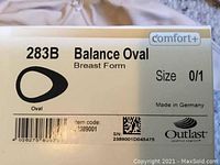 Label on the Amoena 283B Balance Oval breast form box showing size 0/1 and Comfort+ with Made in Germany and Outlast logo.