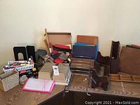 Overview of cardboard file folders in brown, blue, and other colors, various plastic desk organizers and black plastic file holders stacked and grouped together