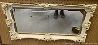Full front view of the rectangular painted wooden mirror showing the Rococo style ornate frame with pastel colors.