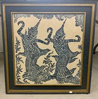Front view of framed Thai temple rubbing artwork depicting two Apsara dancers in blue ink with ornamental details.