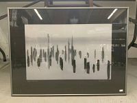 Framed photograph showing the entire artwork titled “Egret’s Slumber” with abstract vertical shapes resembling egrets. The frame is thin metallic with a dark gray mat.