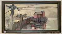 Framed oil painting on board showing coastal dock scene with boat and buildings.