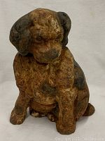 Front view of the cast iron dog doorstop showing rusted surface and worn paint.