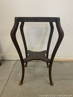 Front view showing curved legs and lower shelf with scalloped edges