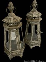 Front view showing both lanterns with hinged doors closed, exhibiting patina and wear on the metal.