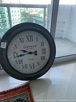 Front view of Glenmont Clock Co. wall clock showing dark frame, Roman numerals, and clock hands at 9:44.