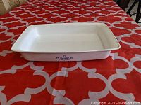 Side view showing the Blue Cornflower design on the white ceramic rectangular baking dish placed on a red patterned tablecloth.
