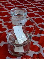 Photo of clear Romanian crystal creamer with applied handle, showing original Colony label and stopper