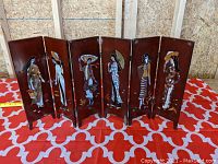 Front view displaying six panels with individual women inlaid with mother of pearl on a lacquered background.