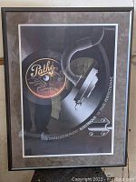 Framed Art Deco poster showing Pathe phonograph horn and recording arm with Pathe logo on record.