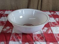 Side angle view of the black Pyrex mixing bowl showing the smooth, black opaque glass surface and clear bottom.