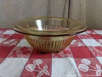 Side angled view showing the ribbed vertical design and flared rim of the amber glass mixing bowl.
