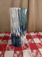 Front side view of blown glass vase showing blue and white drip pattern.