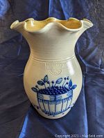 Front view of off-white stoneware vase with blue hand-painted blueberry basket decoration and embossed Salmon Falls maker's mark dated 2002.