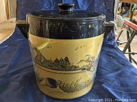 Front and side view of vintage West Bend Thermo-Serv ice bucket featuring detailed black duck-themed scene on tan background with black lid and handles.