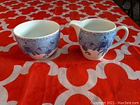 Side-by-side view of Wedgwood creamer and sugar bowl showing blue Mikado pattern detail and shape.