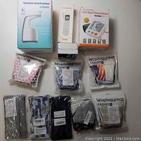 Lot contents showing the soap dispenser box, infrared thermometer box, blood pressure monitor box, pulse oximeter, and multiple packages of cloth masks