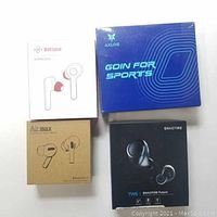 Four boxed wireless earbuds sets from Axloie, Boltune, Airmax, and Enacfire arranged on white surface to show brand names and packaging design