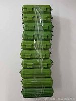 Stack of 10 identical green hard cases with latches, wrapped in plastic for sale as a lot