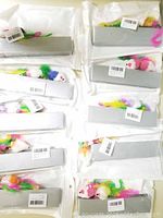 Ten individually packaged cat toys in clear plastic bags with a visible white furry mouse toy with colorful feathers and pink ears inside each package.