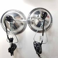 Two Sunlite heated lamps shown from rear, displaying attached cords and metal hangers