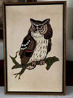 Full view of framed embroidered owl artwork on cream fabric background.