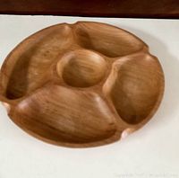 Top and angled view of the vintage teak divided dish showing the four outer compartments and central round section on a white surface with dark background.