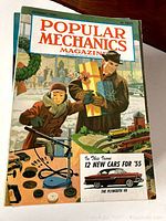Front cover of December 1954 Popular Mechanics featuring people in winter wear with gifts and mechanical tools in foreground.