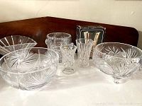 Wide angle photo showing all six crystal dishes including the footed ice bucket and various bowls with cut glass designs.