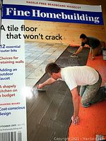 Front cover of a Fine Homebuilding magazine showing a man installing a tile floor, emphasizing home construction tips.
