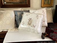 Lot with 2 crocheted cushion covers and 6 pillows. Floral embroidered pillows are wrapped in plastic.