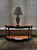 Front view of demilune sofa table with lamp on top, showing overall shape, size, and finish