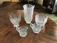 Displays all 5 crystal pieces on a wooden table showing various shapes and detailed etched patterns.