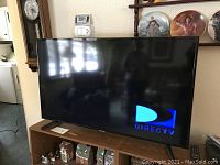 Front view of Samsung TV powered on showing DirecTV logo